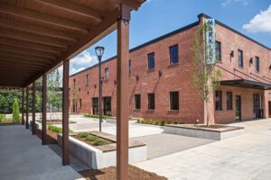 Exterior view of a modern brick building labeled "Market," featuring a covered walkway and landscaped courtyard.