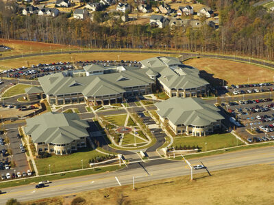 Aerial view of a large educational facility with multiple connected buildings and a surrounding parking area.