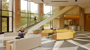 A modern lobby with geometric flooring, multiple seating areas, large windows, and a staircase. People are sitting and walking.