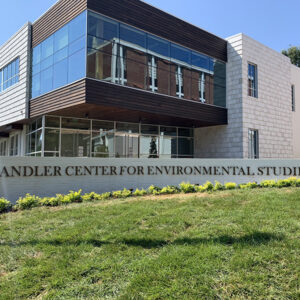 Building with "Chandler Center for Environmental Studies" sign, modern architecture, large windows, and a grassy foreground.