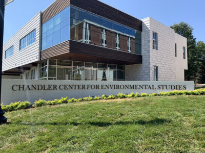 Building with "Chandler Center for Environmental Studies" sign, modern architecture, large windows, and a grassy foreground.